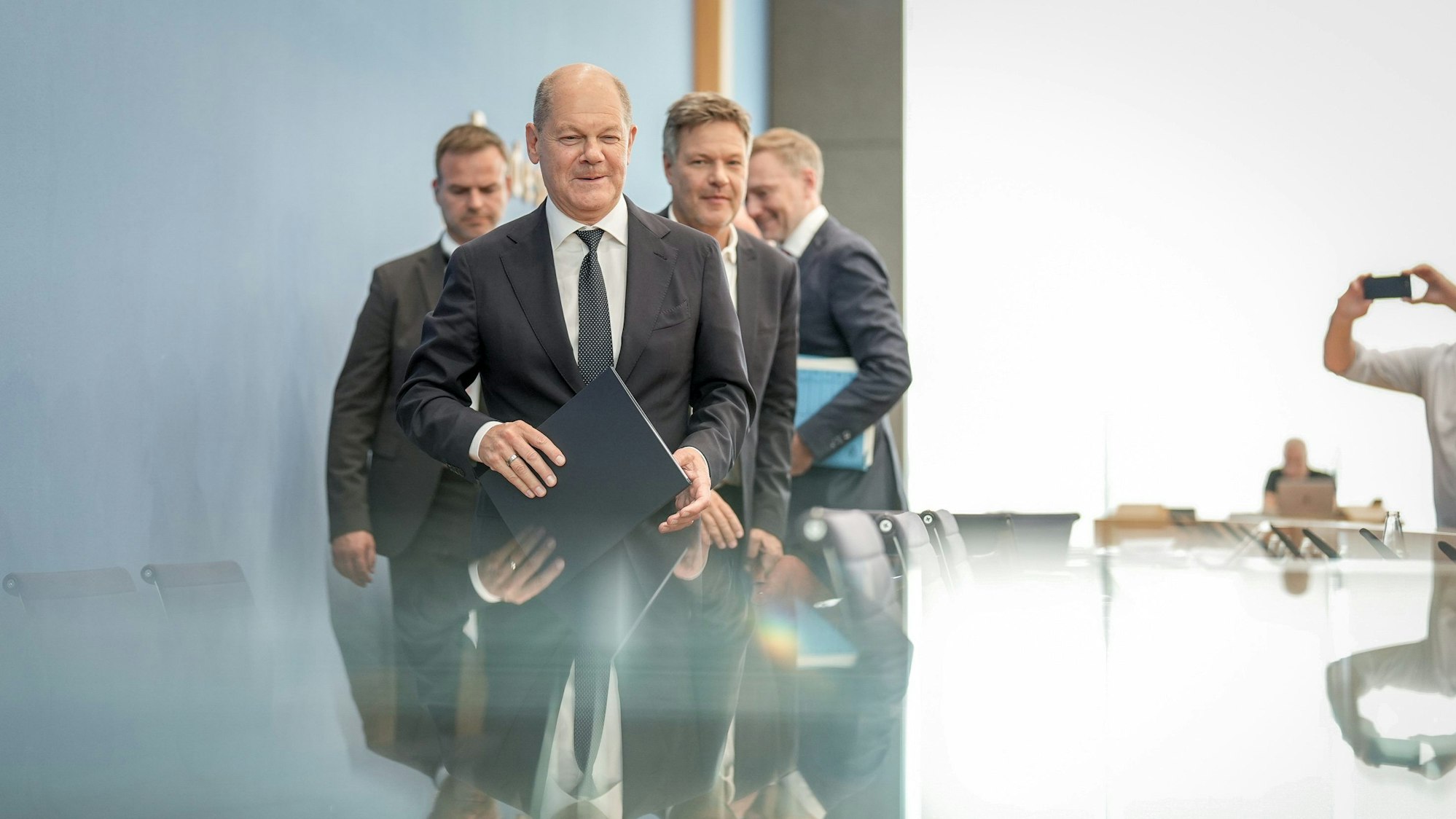 Bundeskanzler Olaf Scholz (SPD, l-r), Robert Habeck (Bündnis 90/Die Grünen), Bundesminister für Wirtschaft und Klimaschutz, und Christian Lindner (FDP), Bundesminister der Finanzen, verlassen die Pressekonferenz zum Haushaltsplan 2025.