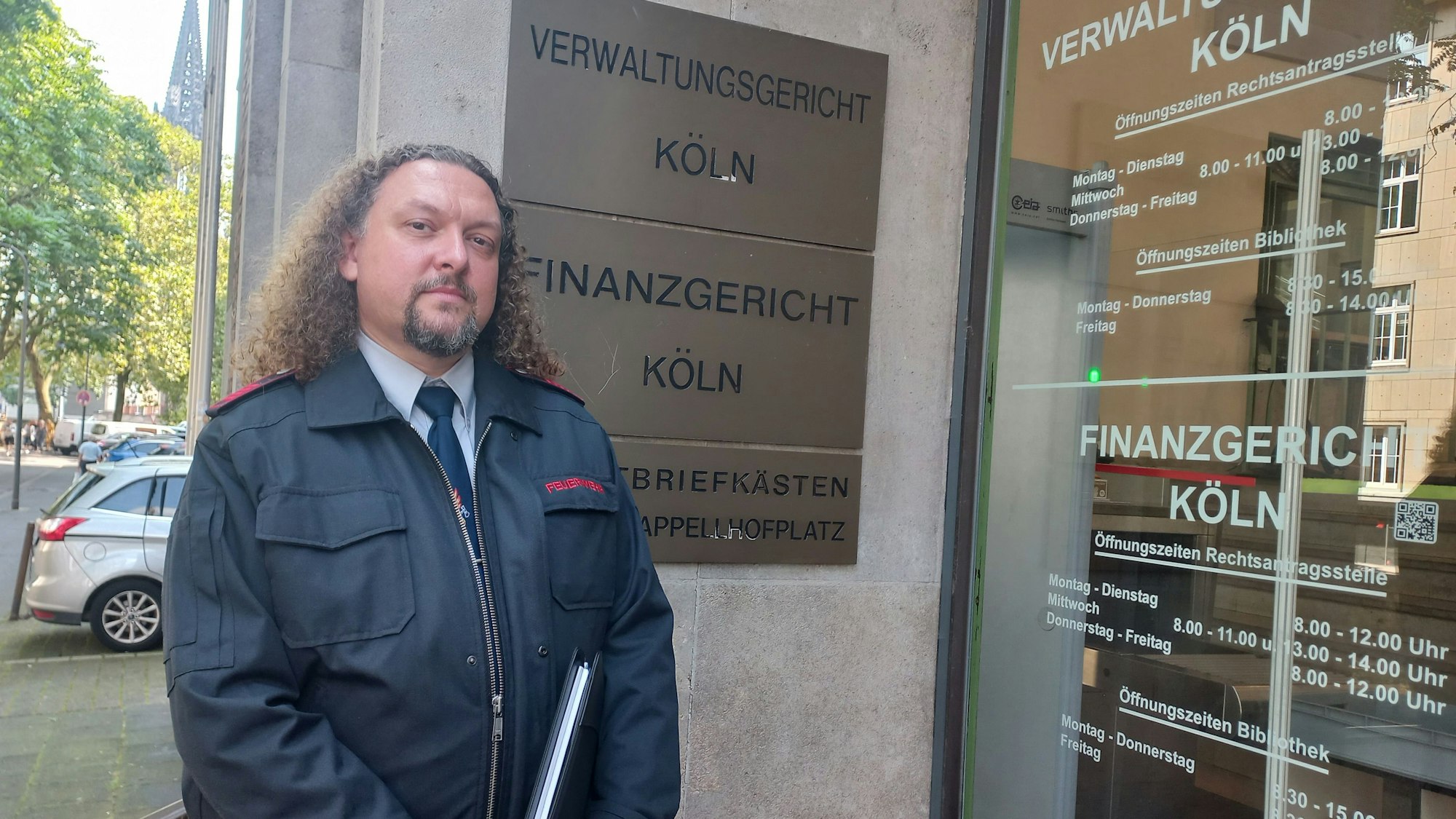 Foto eines Mannes, der vor dem Gebäude des Kölner Verwaltungsgerichtes steht.
