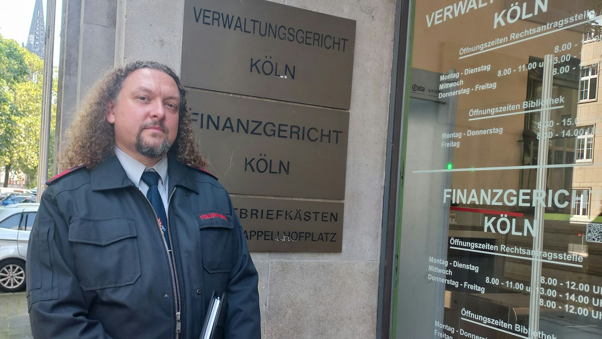 Zu sehen ist ein Feuerwehrmann vor dem Gebäude des Kölner Verwaltungsgerichts.