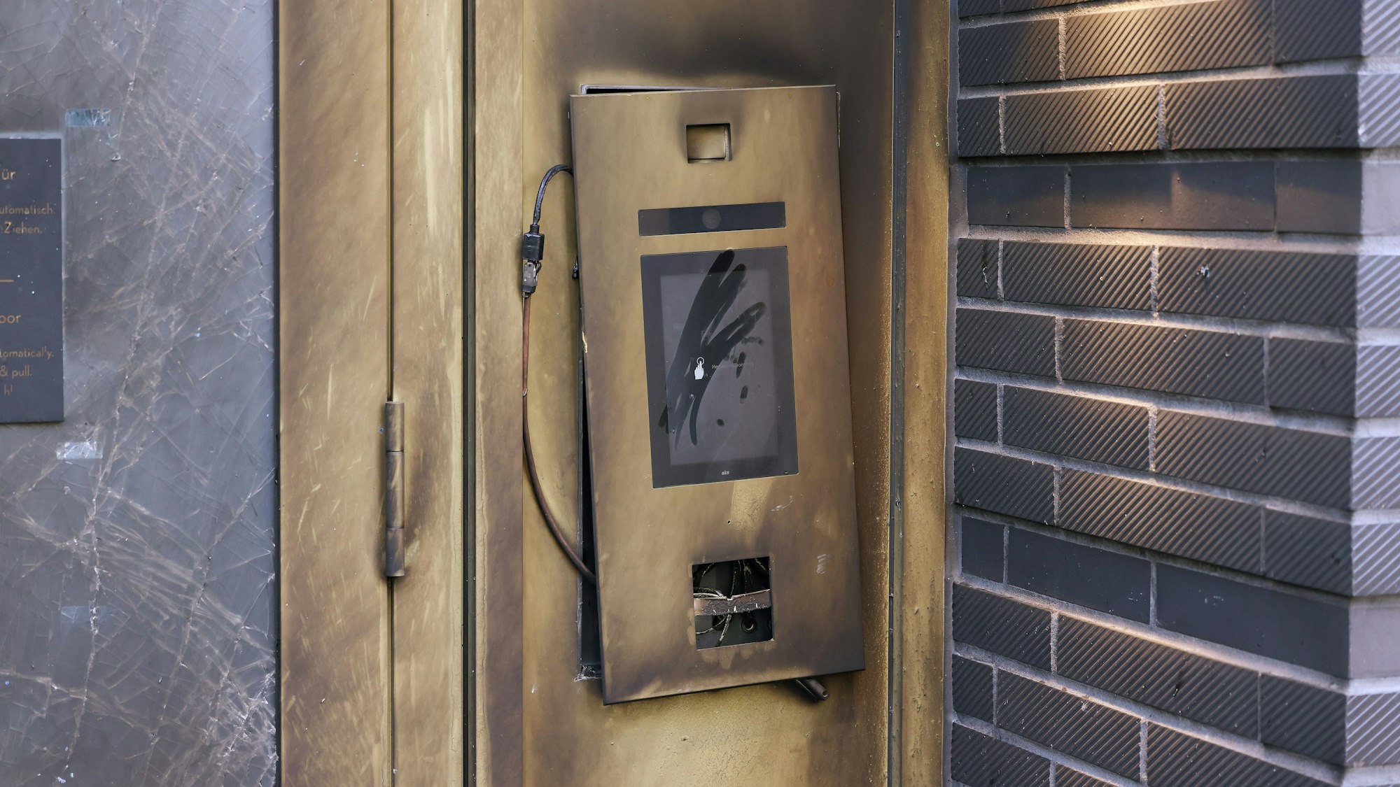 Der Eingangsbereich bei einem Mehrfamilienhaus ist durch eine Explosion beschädigt worden. Die Glastür und Türrahmen sind beschädigt worden.