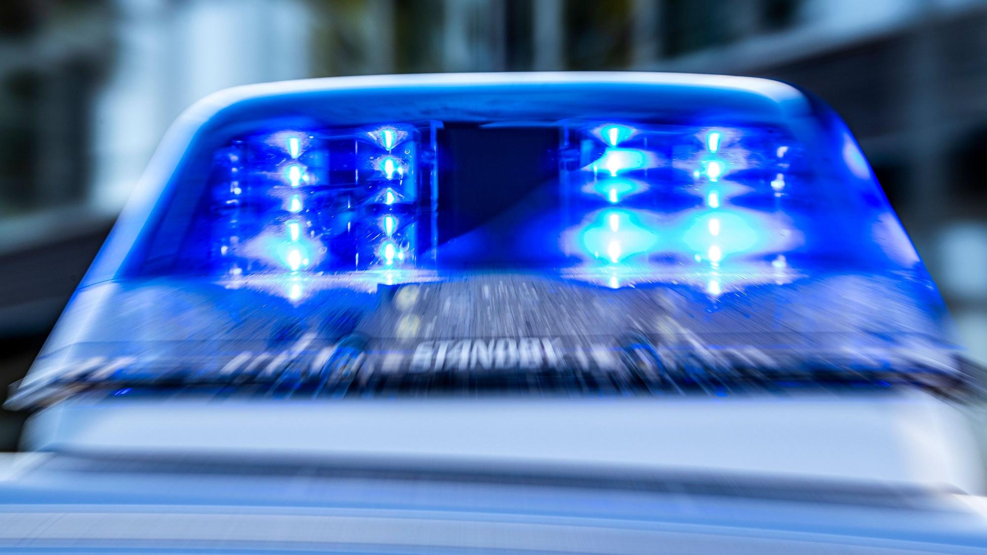 Das Blaulicht an einem Polizeiwagen ist eingeschaltet.