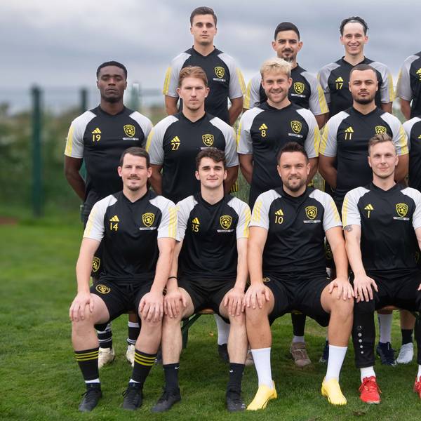 Der SC Germania Erftstadt-Lechenich hat sich für ein Mannschaftsfoto auf einem Rasen versammelt. Im Hintergrund ist der Himmel bewölkt.