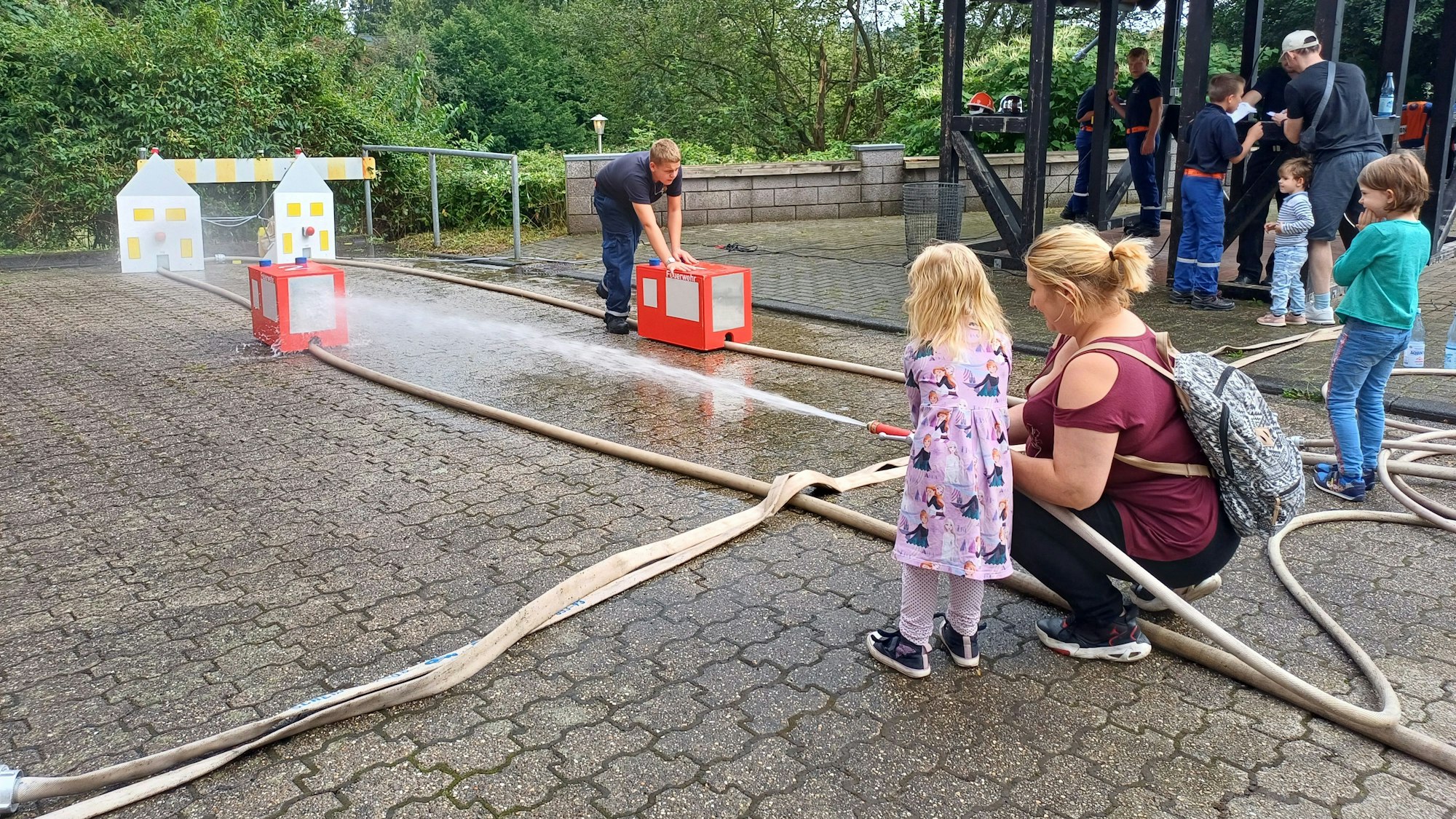 Die dreijährige Marie bringt mit dem Druck des Wassers ein Holzauto ins Rollen.
