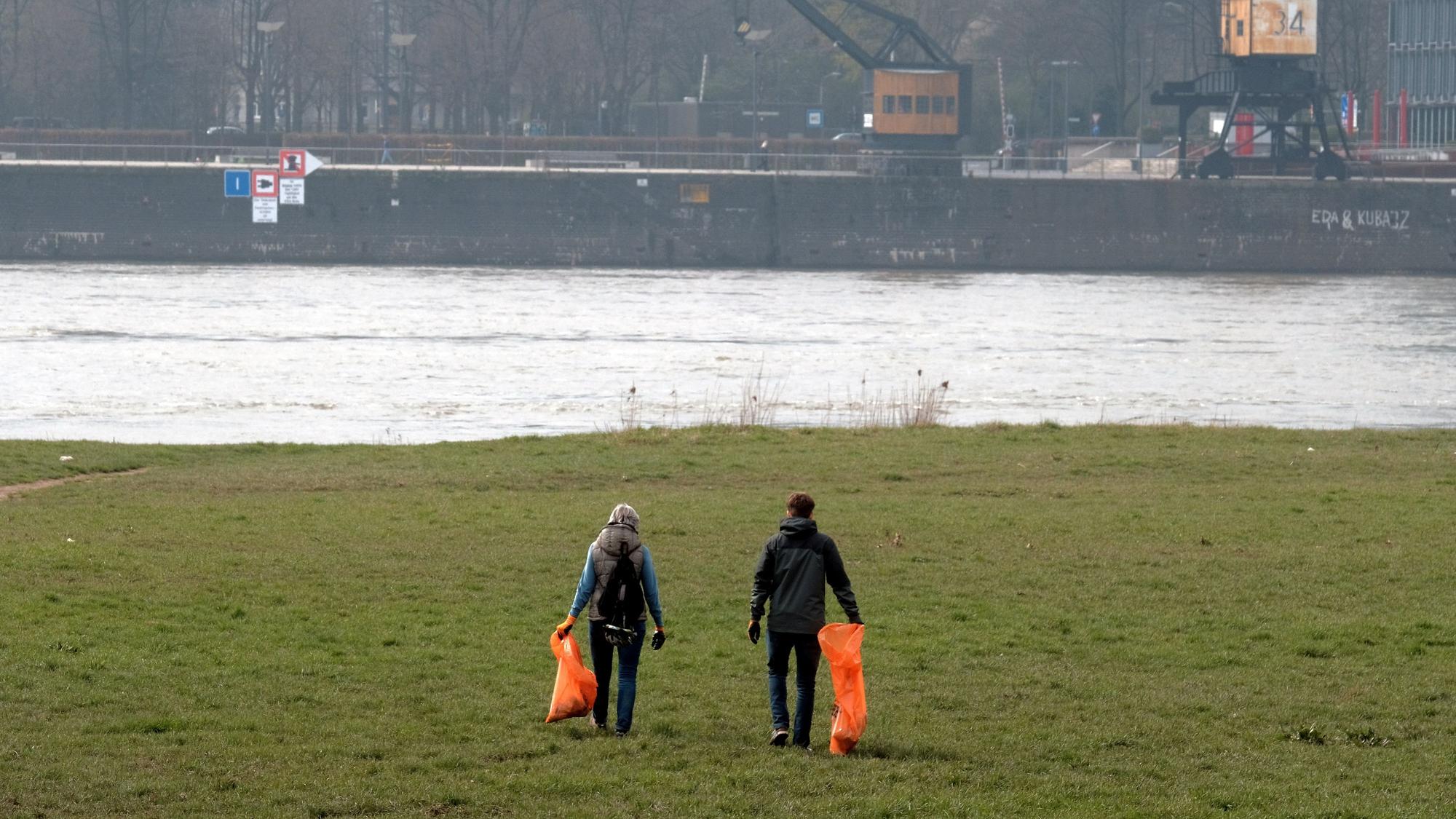 Freiwillige sammeln Müll am Rheinufer