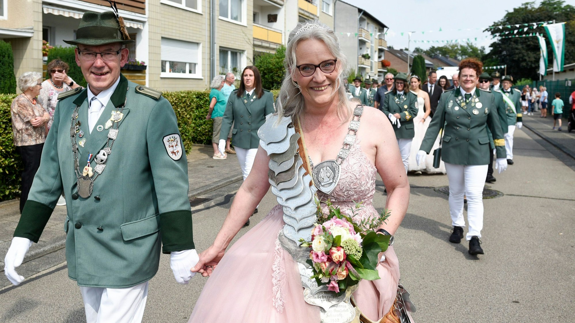 Eine Frau in einem Kleid und ein Mann in Uniform laufen durch die Straßen.