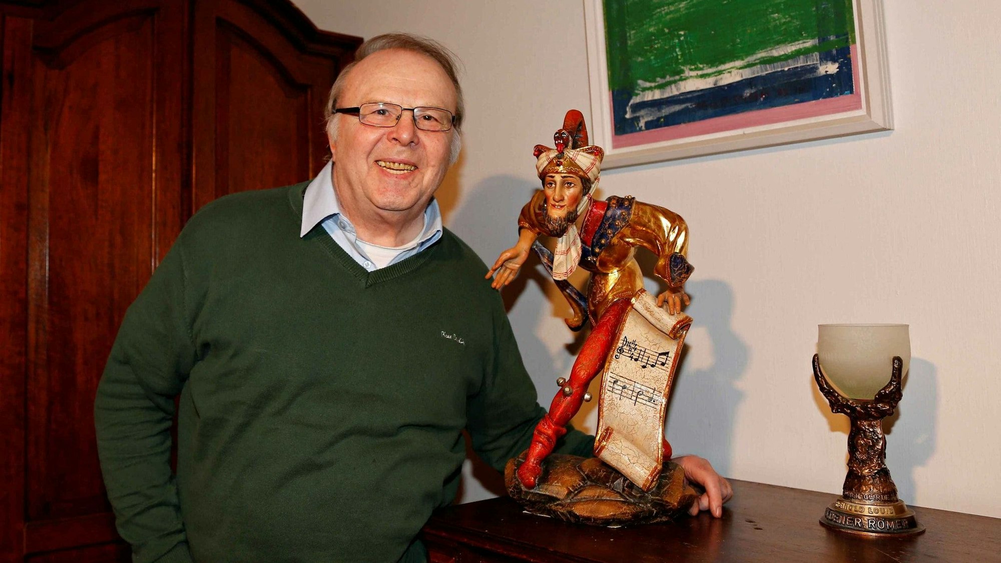 Reinold Louis steht in seiner Wohnung und schaut in die Kamera.