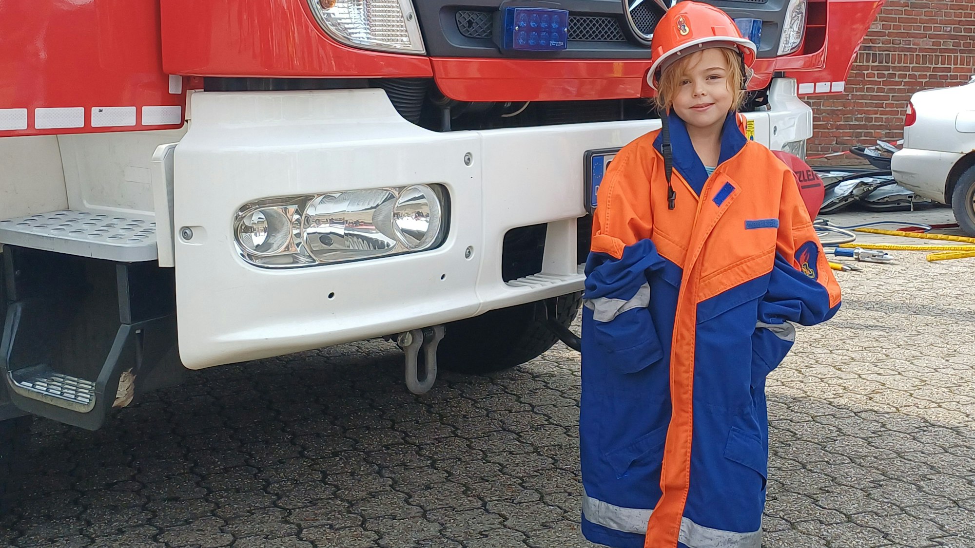 Die zukünftige Feuerwehrfrau Leonie darf Schutzkleidung ausprobieren.