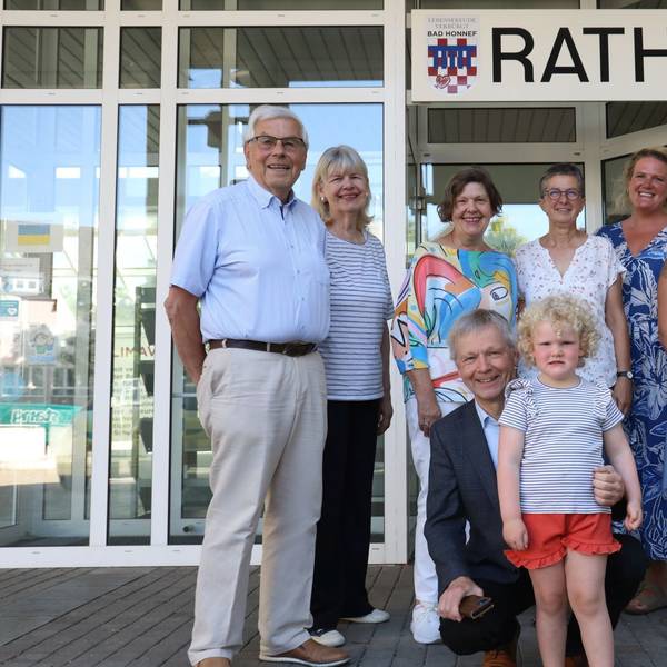Eine Gruppe Erwachsener mit einem kleinen Mädchen vor dem Eingang zum Bad Honnefer Rathaus.