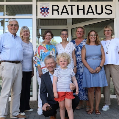 Eine Gruppe Erwachsener mit einem kleinen Mädchen vor dem Eingang zum Bad Honnefer Rathaus.