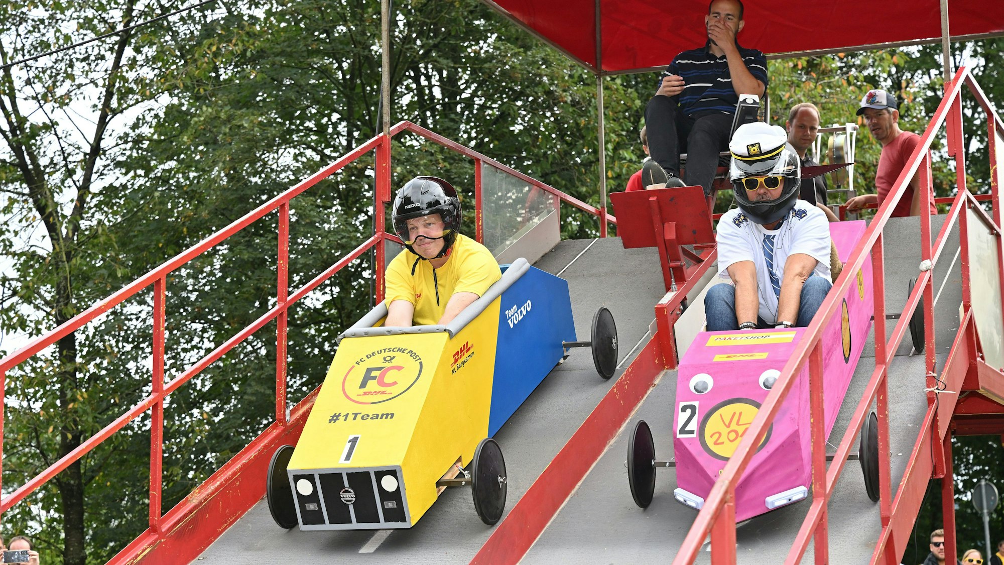 Zwei Seifenkosten starten von einer Rampe beim Seifenkistenrennen in Overath.