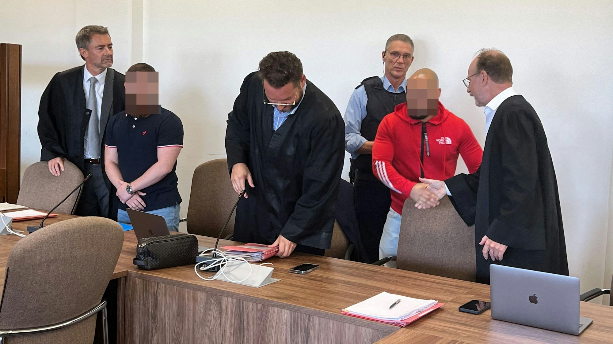 Die Angeklagten mit ihren Verteidigern beim Prozessauftakt im Kölner Landgericht.