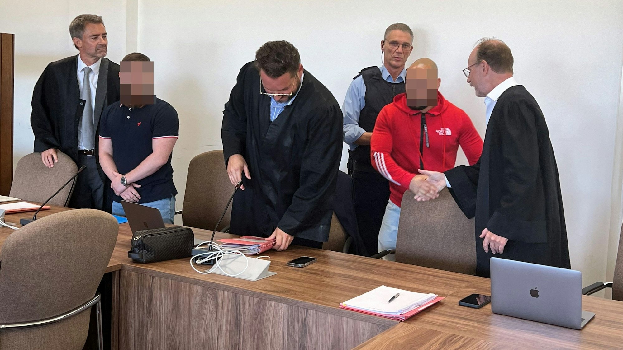 Die Angeklagten mit ihren Verteidigern Marc Donay, Peter Nickel und Dirk Schlei beim Prozessauftakt im Kölner Landgericht