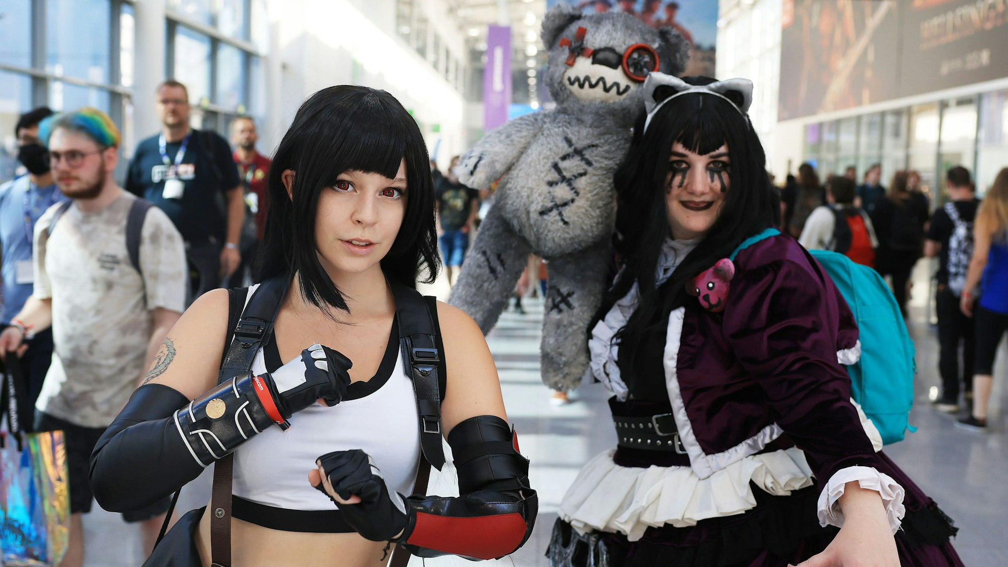 Cosplayers dressed up walk across the exhibition grounds at Gamescom 2022.