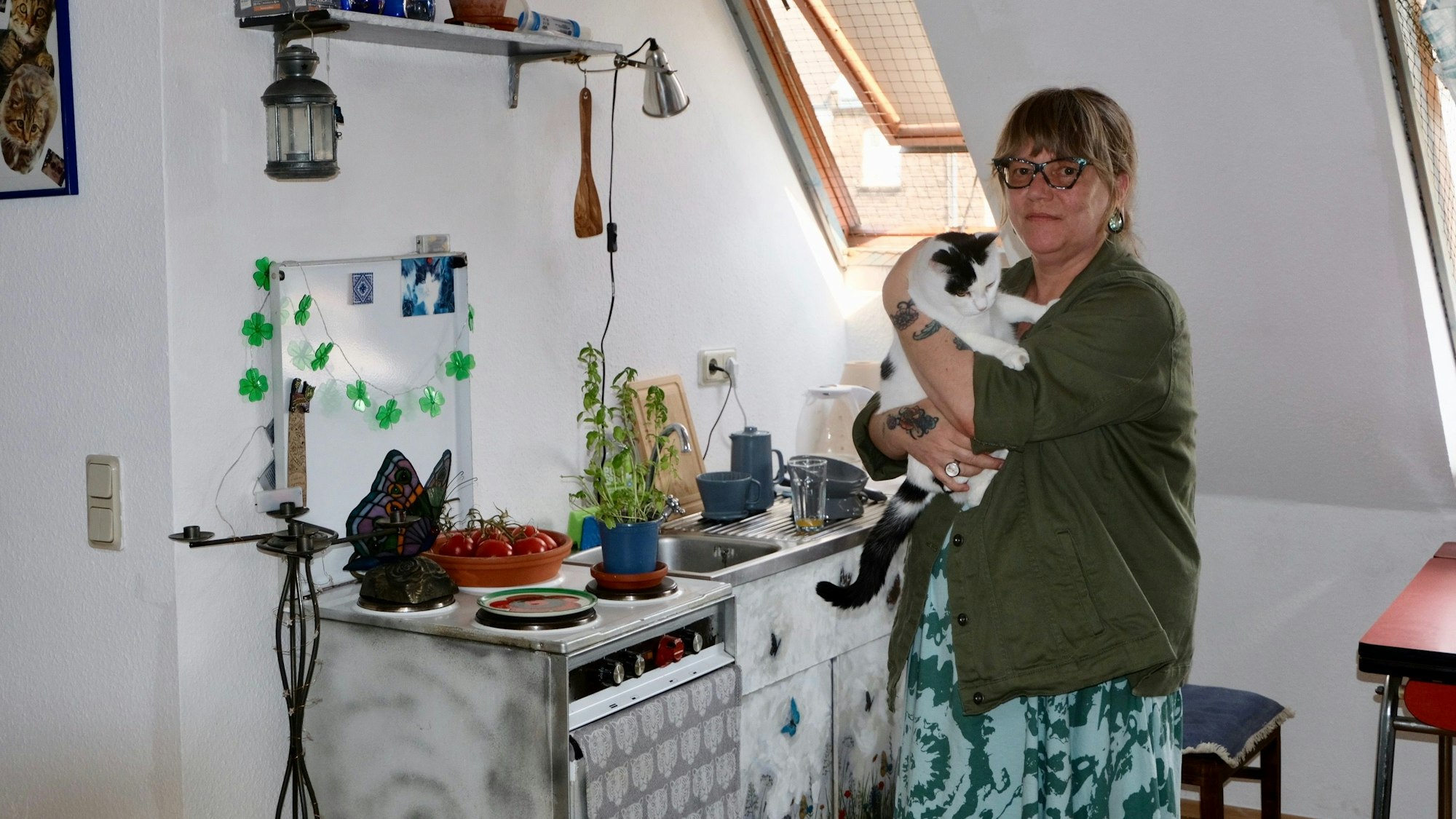 Bettina Isken mit ihrer Katze Trudi in ihrer kleinen Dachgeschosswohnung.
