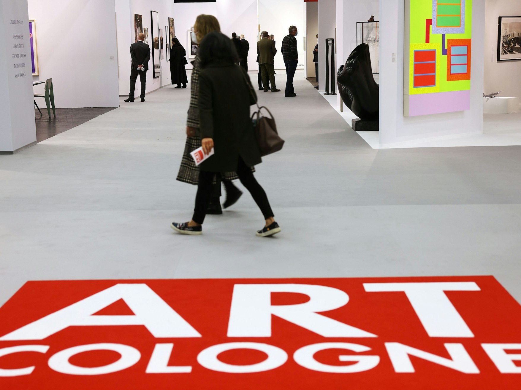 Messebesucher gehen über die Art Cologne.