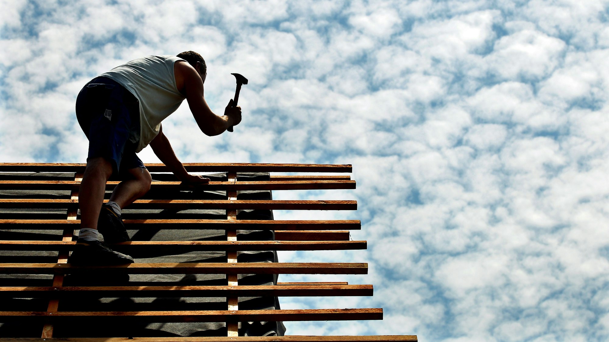 Ein Dachdecker arbeitet auf einer Baustelle in der Sommerhitze.