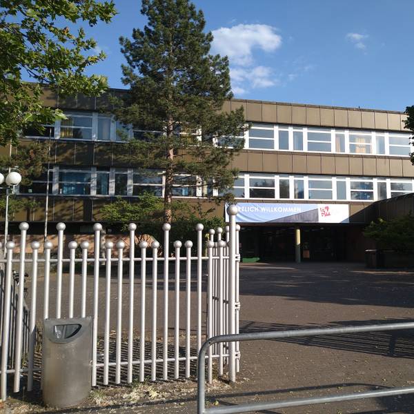 Zu sehen ist das Heinrich-Mann-Gymnasiums in Chorweiler von außen.