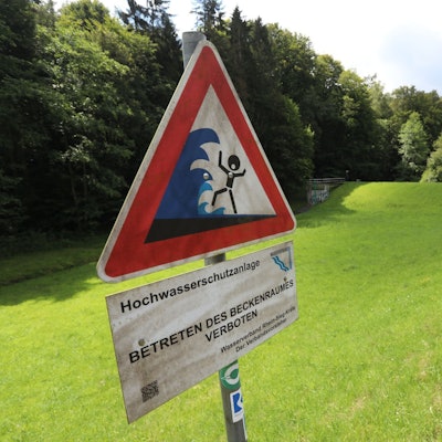 Ein Warnschild vor Hochwasser am Rande des Hochwasserrückhaltebeckens.