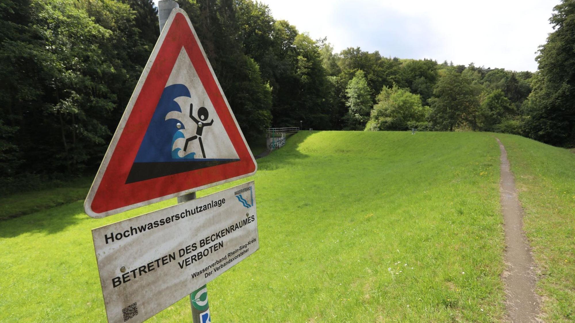 Ein Warnschild vor Hochwasser am Rande des Hochwasserrückhaltebeckens.