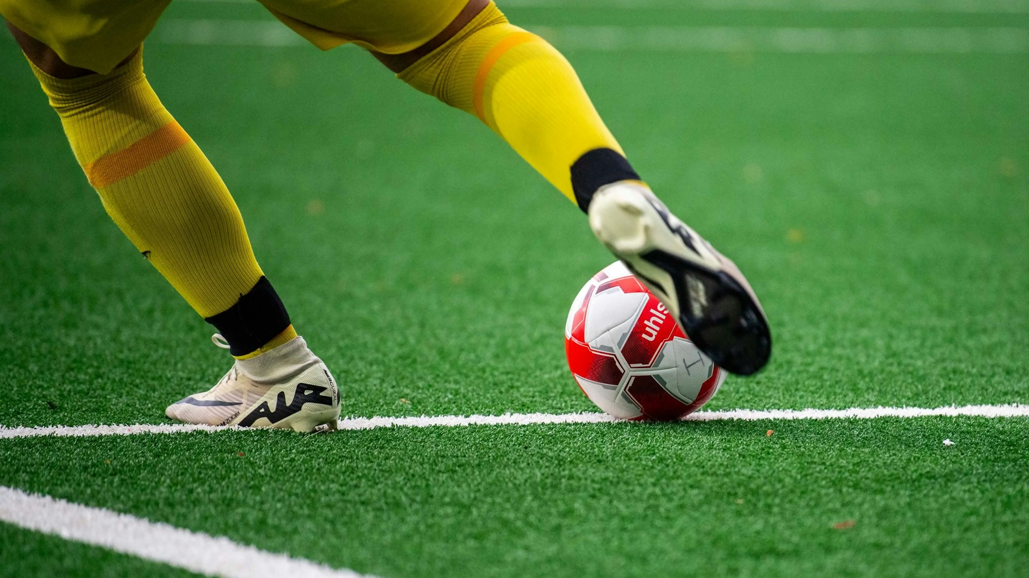 Das Bild zeigt einen Torwart, der einen Ball schießt.