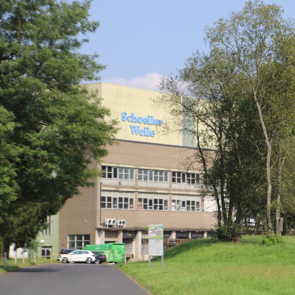 Das große Lagergebäude trägt den Schriftzug Schoeller Wolle.