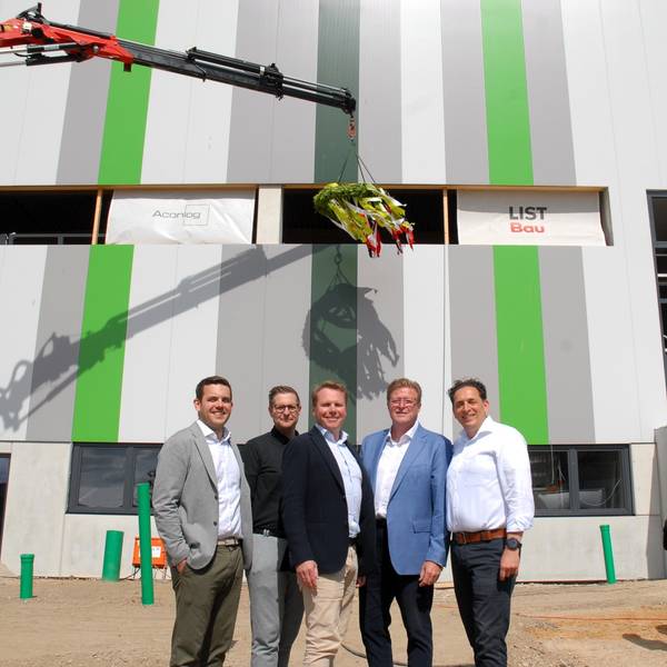 Männer stehen vor einer Lagerhalle,