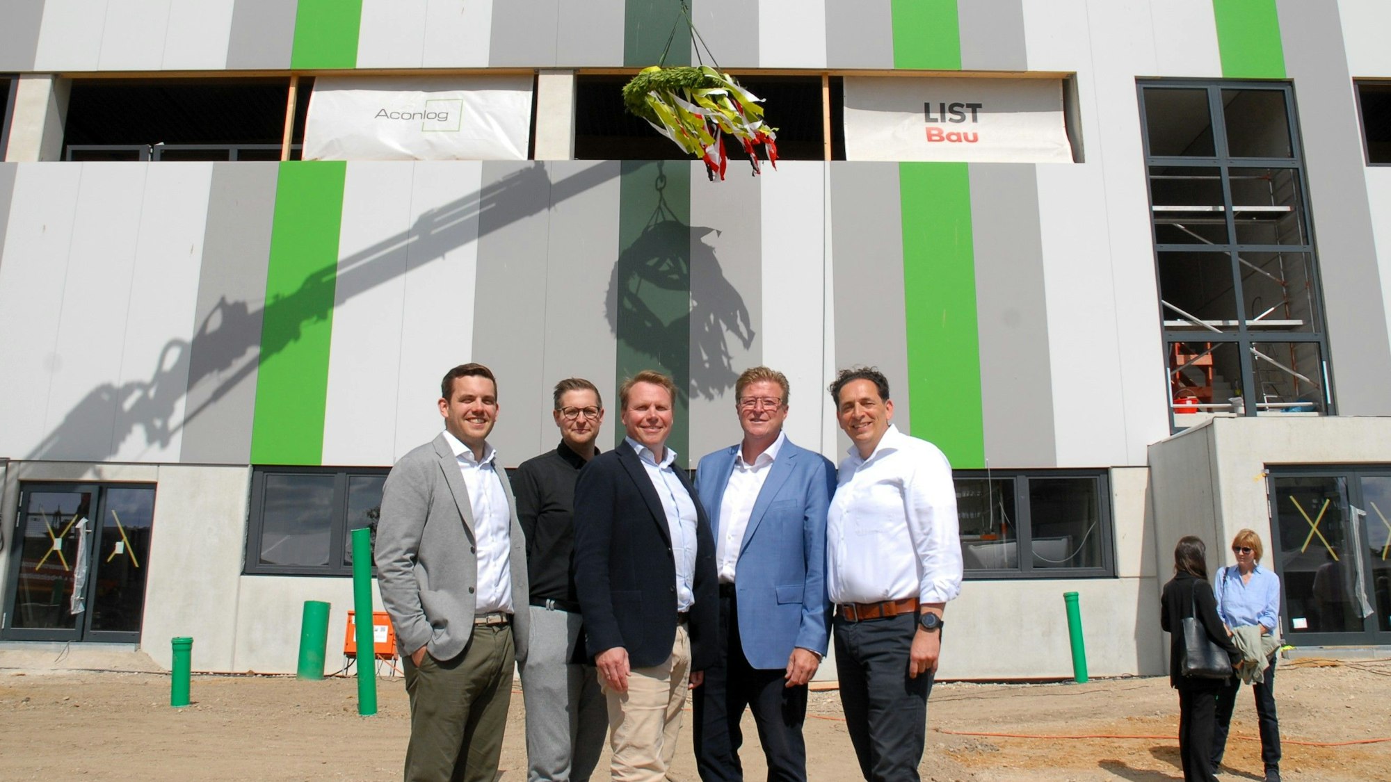 Männer stehen vor einer Lagerhalle,