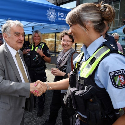 Innenminister Herbert Reul, links im Bild, begrüßt eine Polizistin am Lindenplatz in Gummersbach.