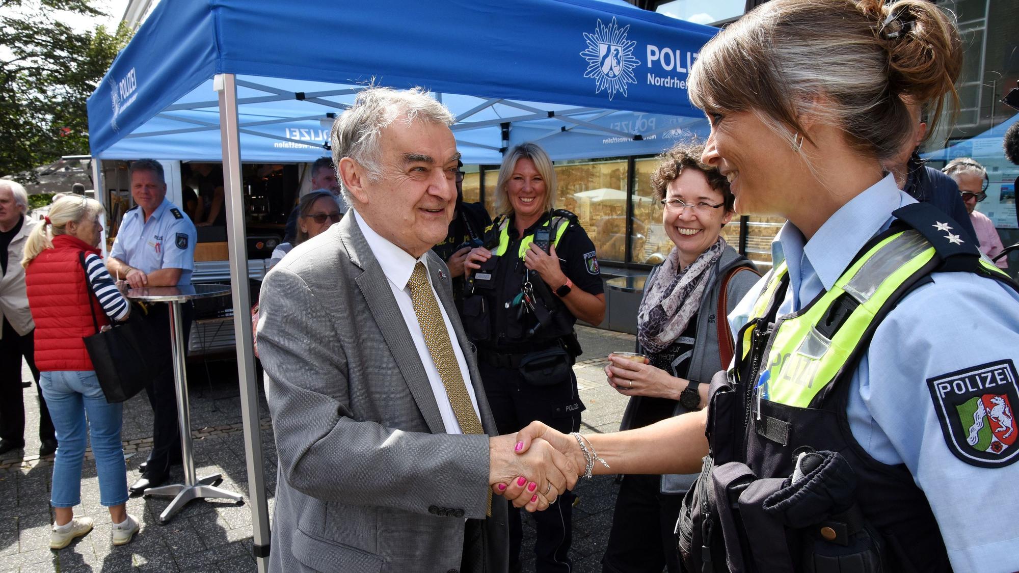 Innenminister Herbert Reul, links im Bild, begrüßt eine Polizistin am Lindenplatz in Gummersbach.
