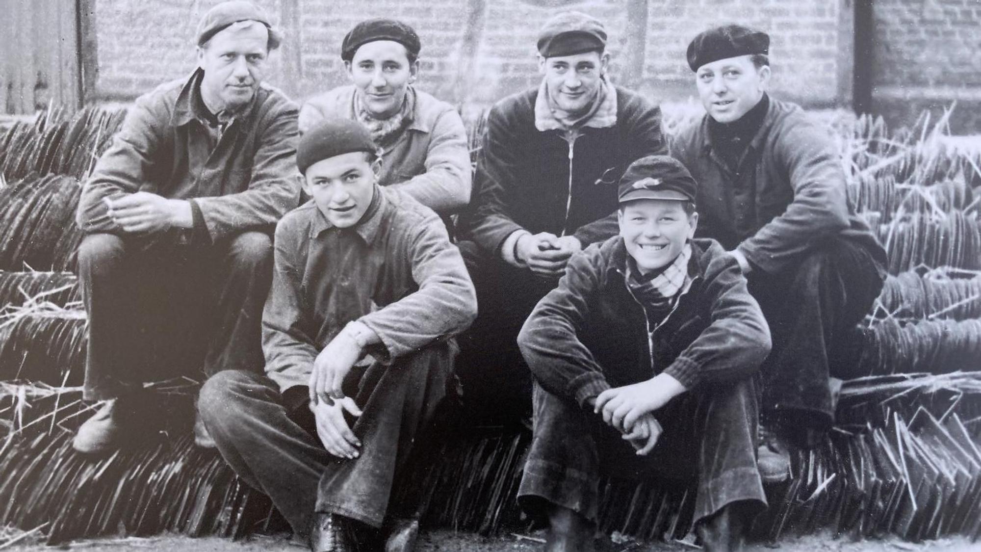 Handwerker sitzen in einem Schwarz-Weiß-Gruppenfoto zusammen.