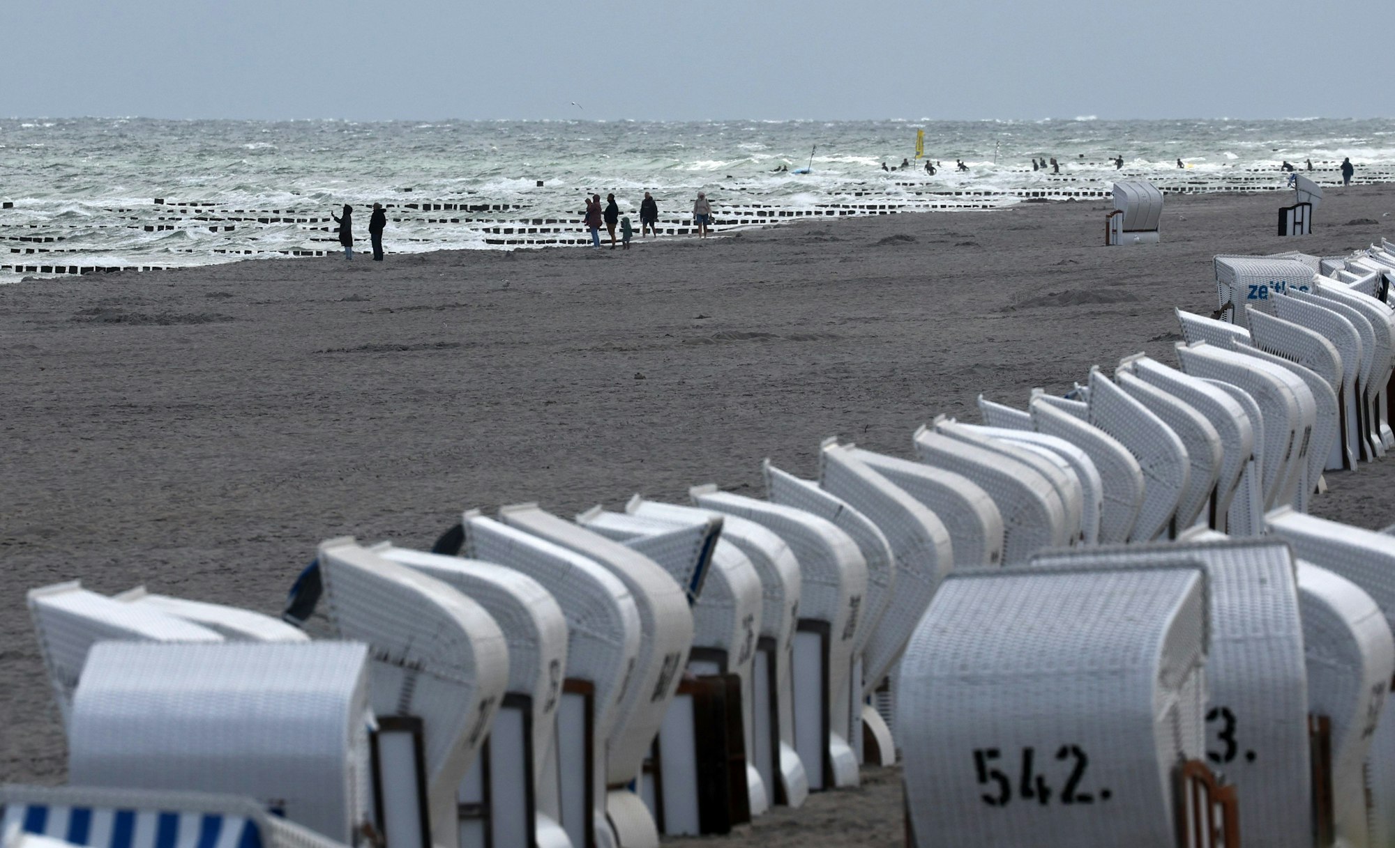 21.08.2024, Mecklenburg-Vorpommern, Zingst: Die Strandkörbe sind leer, an der Ostsee sind nur wenige Spaziergänger unterwegs. Regen und Wind sorgen für eine kurze Sommerpause an der Ostsee. Foto: Bernd Wüstneck/dpa +++ dpa-Bildfunk +++