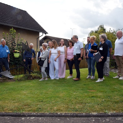 Eine Gruppe steht auf einer Wiese zusammen.