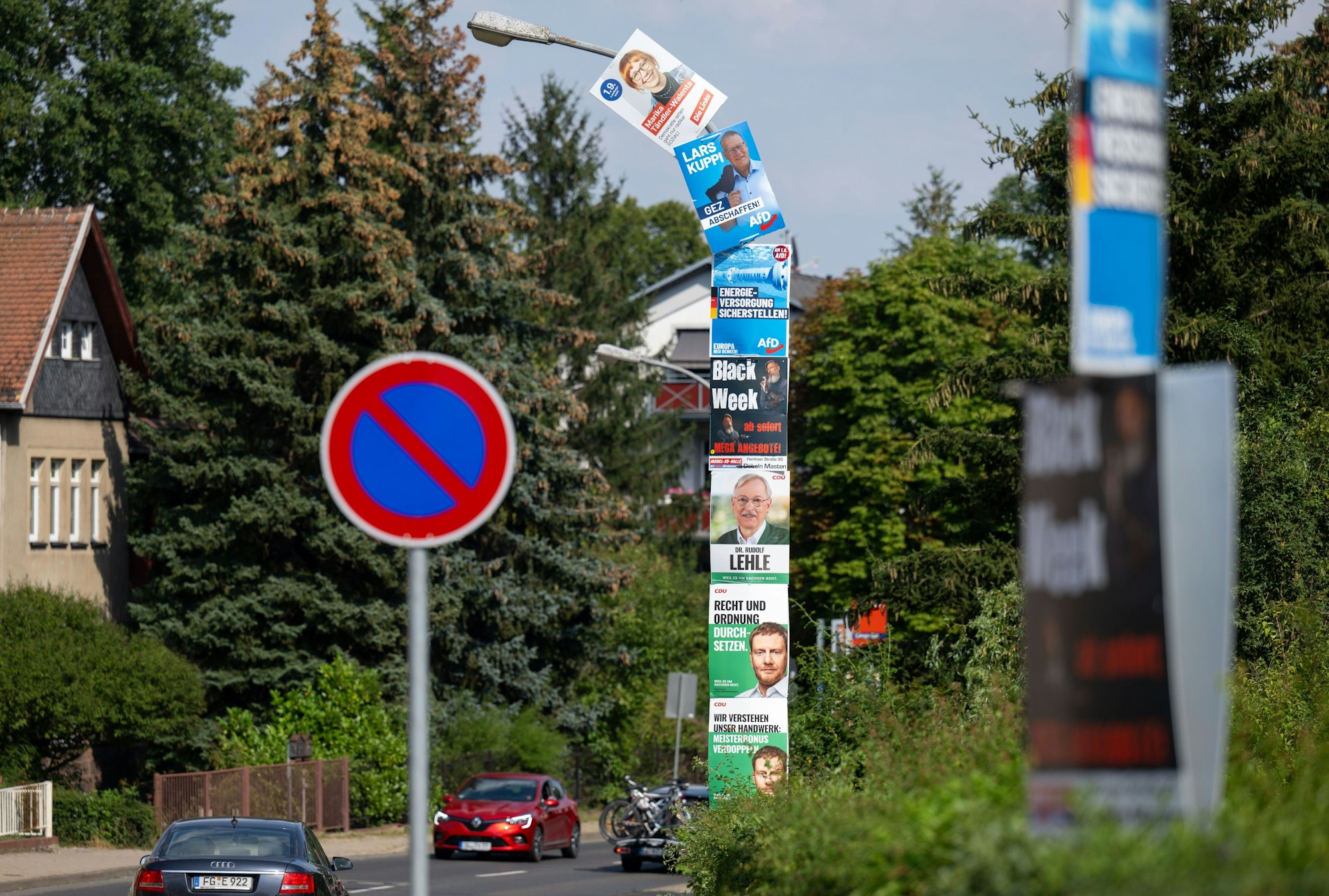 01.08.2024, Sachsen, Döbeln: Sechs Wahlplakate von CDU, AfD und Linkspartei und ein Werbeplakat umhüllen einen Laternenmast am Stadtrand von Döbeln. Am 1. September wird in Sachsen ein neuer Landtag gewählt. Foto: Hendrik Schmidt/dpa - ACHTUNG: Nur zur redaktionellen Verwendung im Zusammenhang mit der aktuellen Berichterstattung über die genannten Wahlen und nur mit vollständiger Nennung des vorstehenden Credits +++ dpa-Bildfunk +++