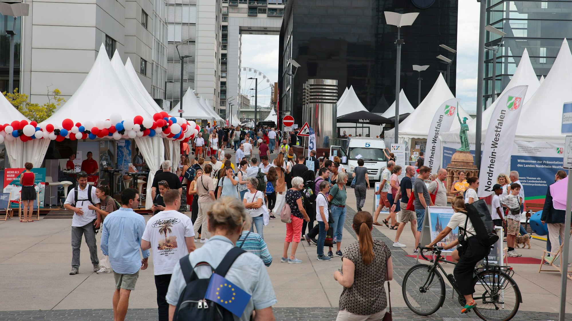 Menschen laufen bei den Kranhäusern über den NRW-Tag in Köln.