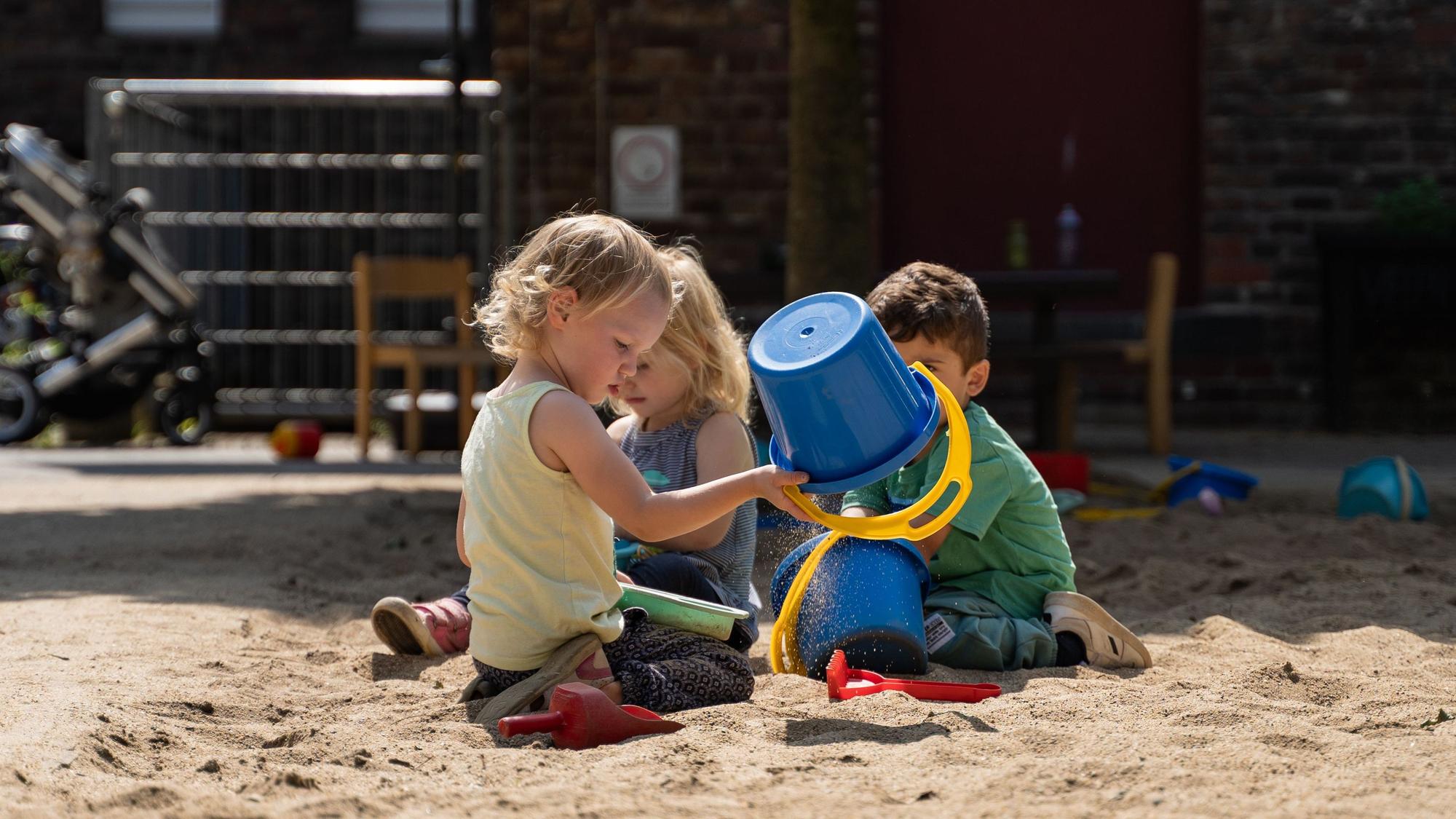 Kinder spielen an einer Leverkusener Kita im Sand.
