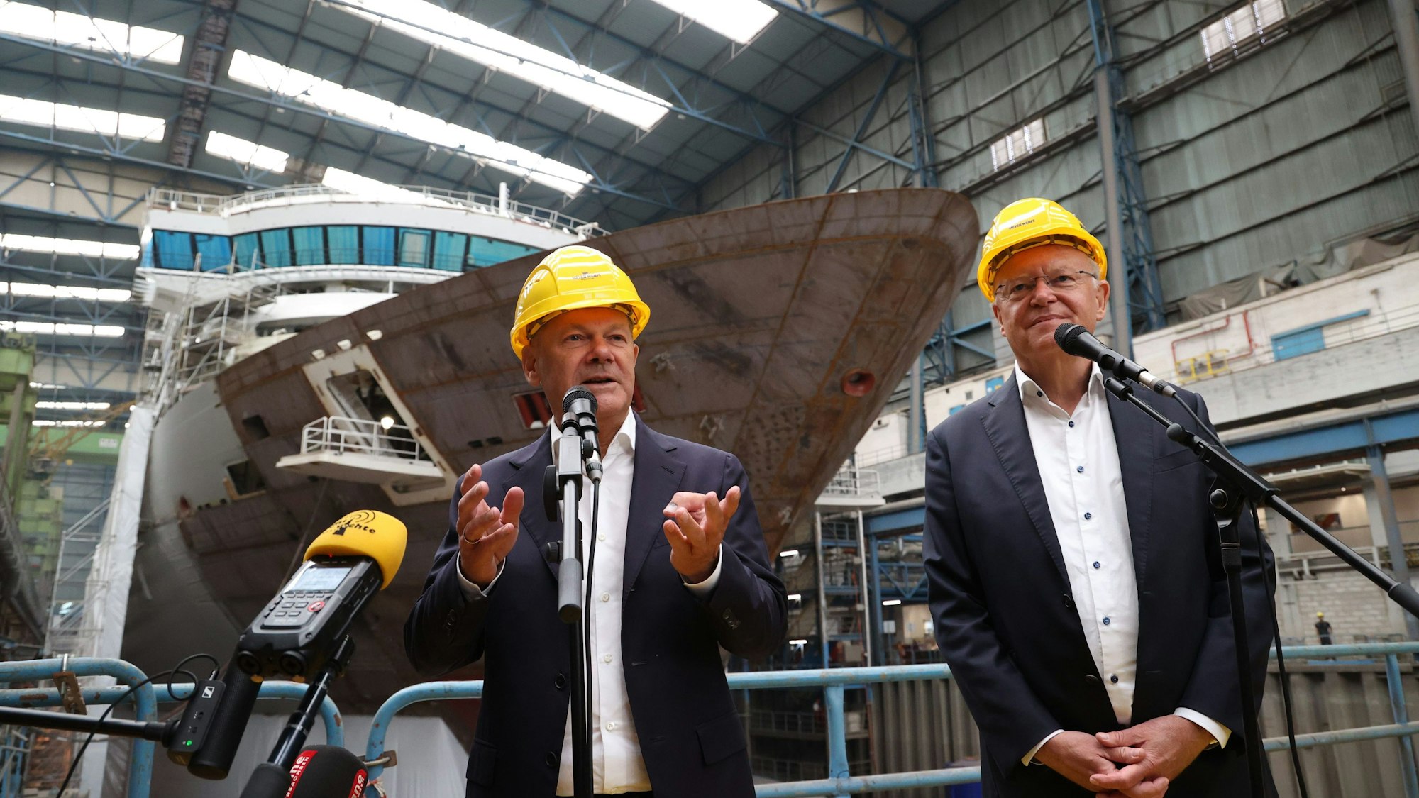 Bundeskanzler Olaf Scholz (SPD, l) und Stephan Weil (SPD), Ministerpräsident von Niedersachsen, geben in einer Werkshalle der Meyer Werft ein Presse-Statement ab.