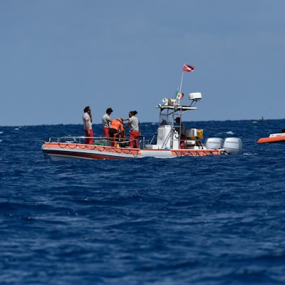 Ein Boot mit Tauchern sucht im Meer nach Vermissten.