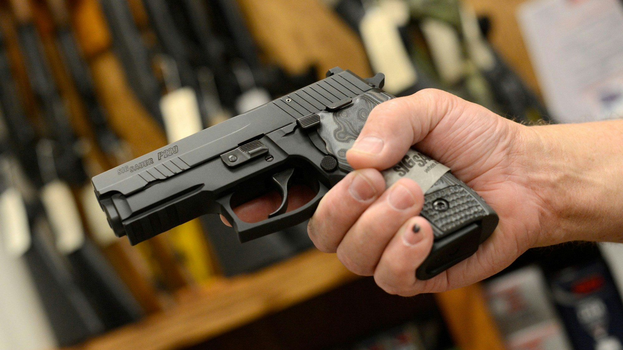 Eine Hand hält eine Waffe.