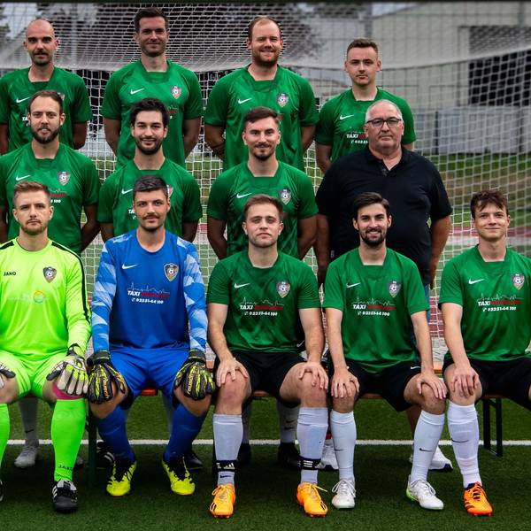 Beim Mannschaftsfoto sitzen und stehen die Herren des SG Flamersheim/Kirchheim vor einem Fußballtor.