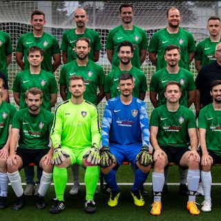 Beim Mannschaftsfoto sitzen und stehen die Herren des SG Flamersheim/Kirchheim vor einem Fußballtor.