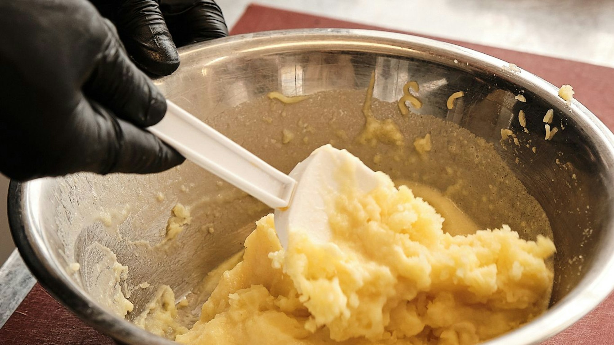 Die ausgedämpften weichen Kartoffeln stampfen oder noch besser pressen.