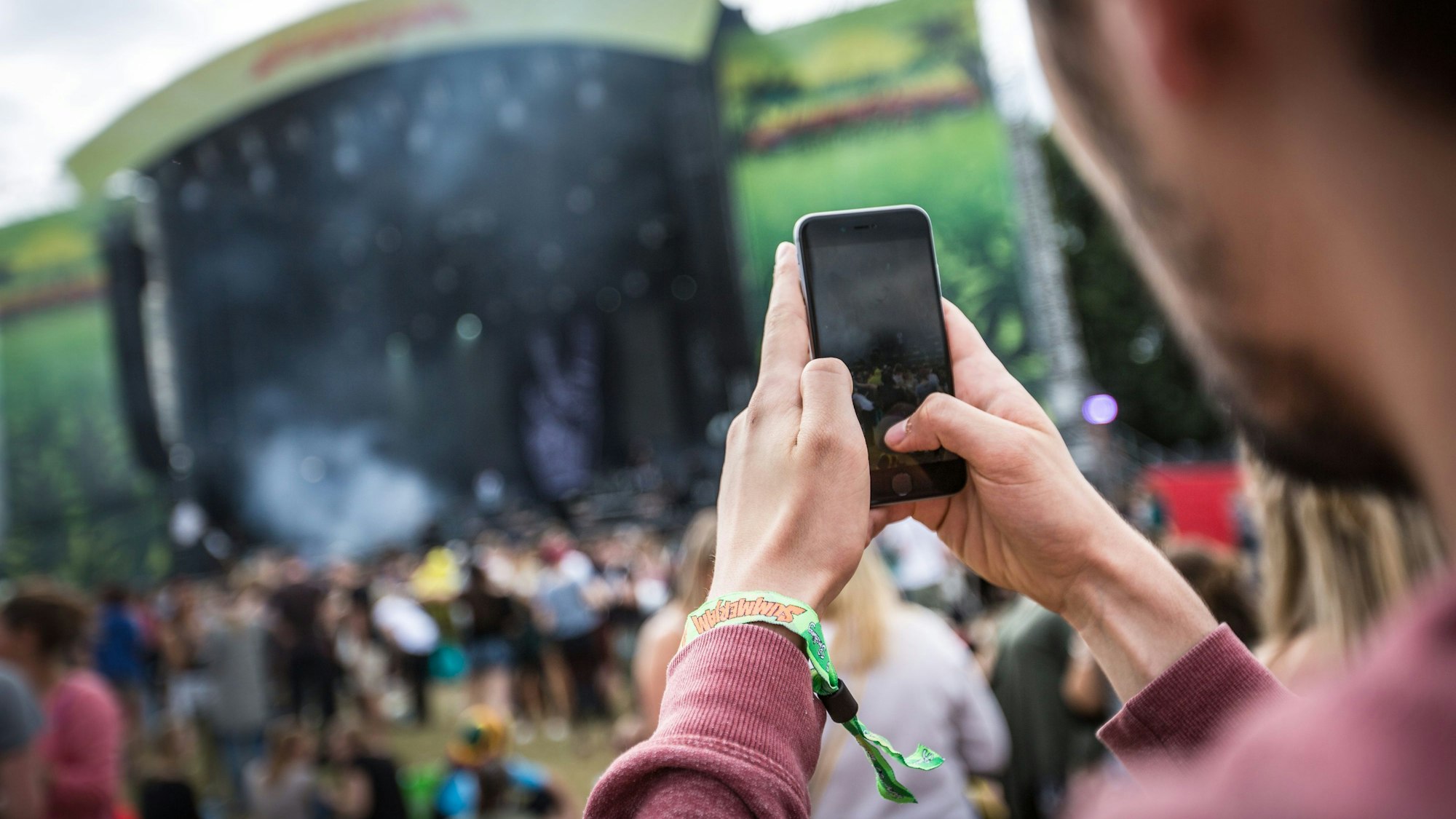 Ein Festivalbesucher fotografiert mit seinem Handy.
