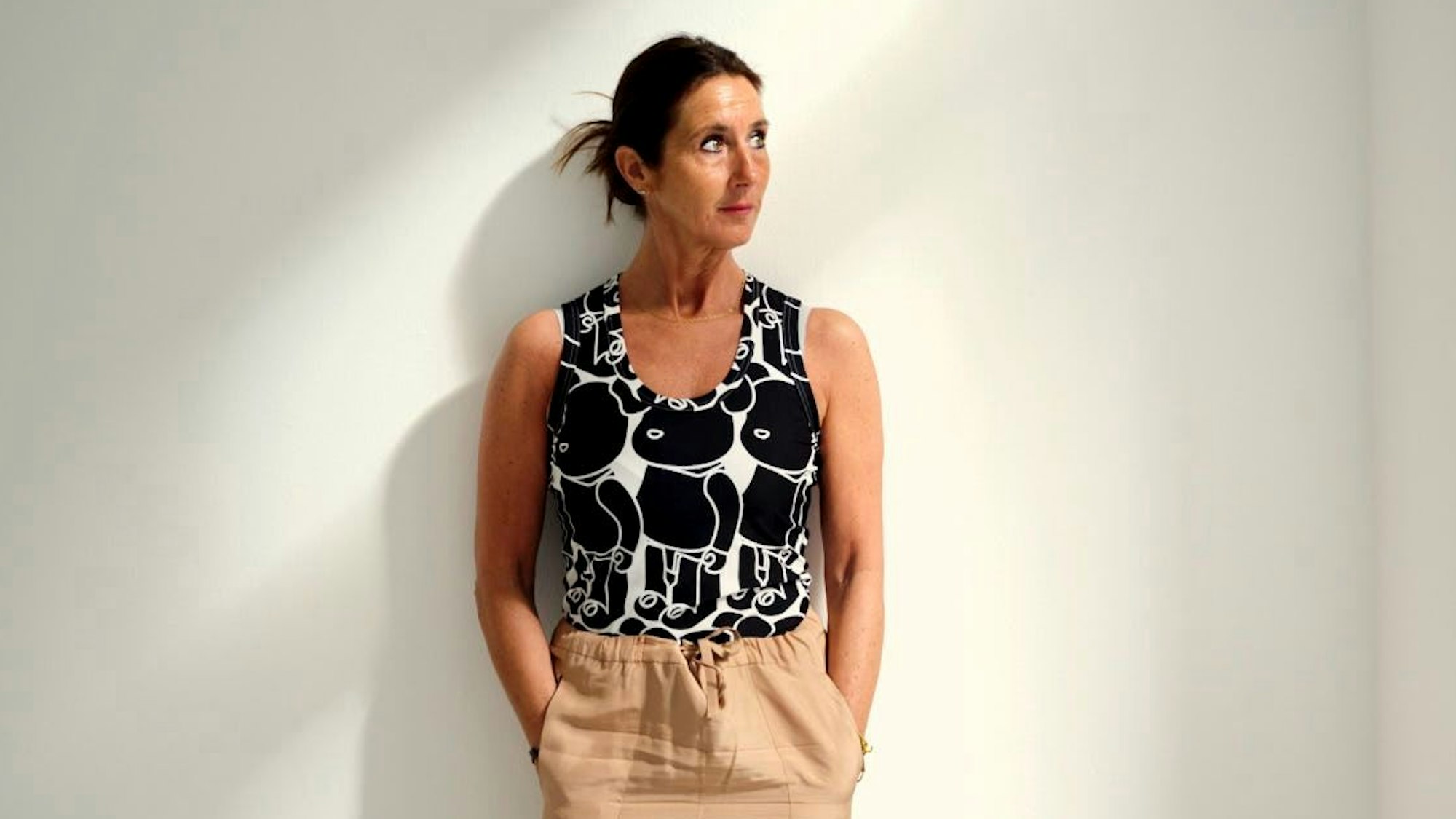 Marietta Clages steht vor einer Wand und schaut zur Seite.