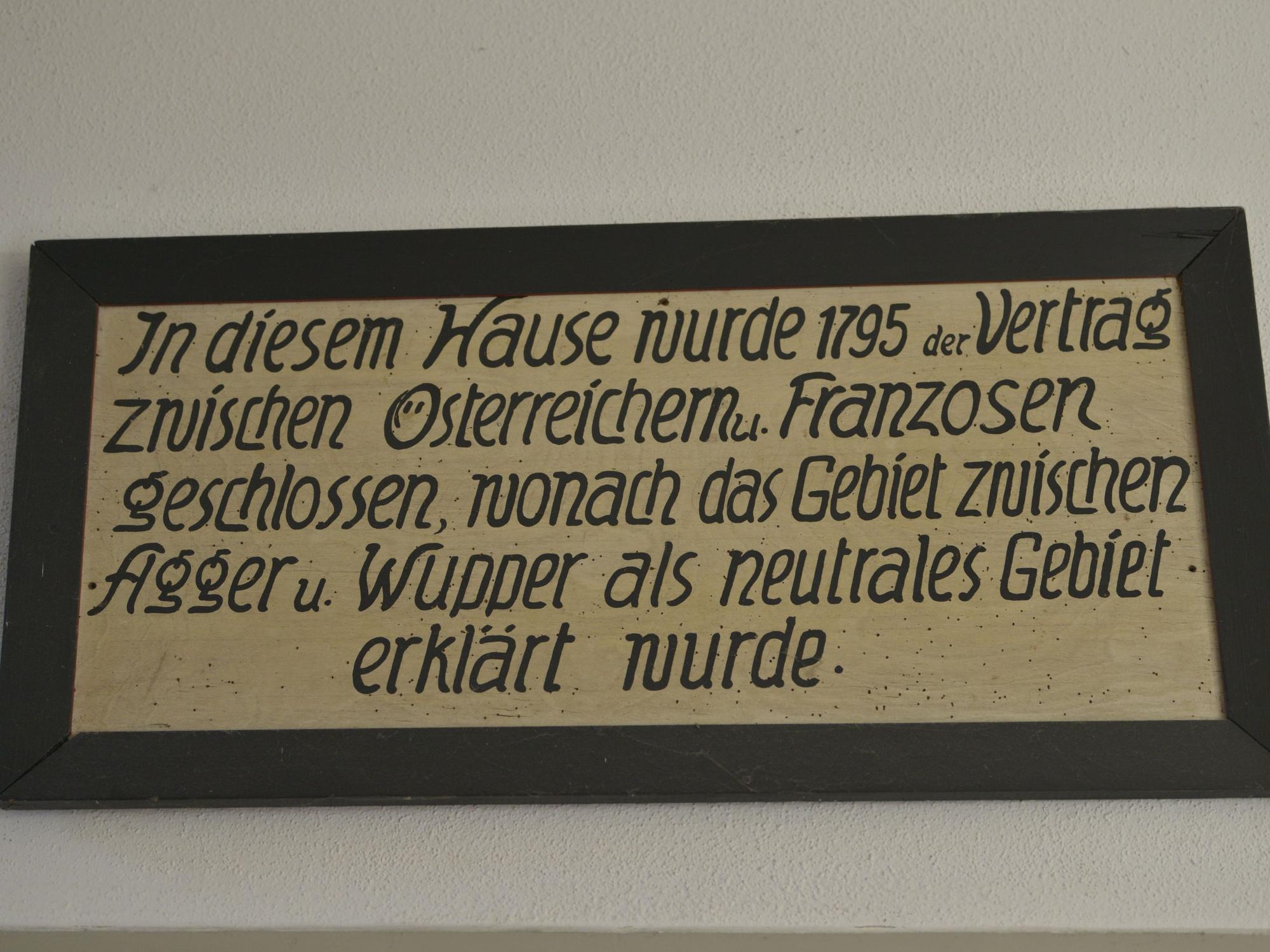 Das Schild erinnert an den Friedenschluss, der in dem Gebäude unterzeichnet wurde.