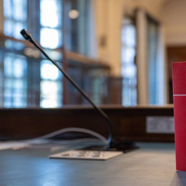 Das Gesetzbuch "Strafrecht" steht auf einem Tisch in einem Verhandlungssaal.