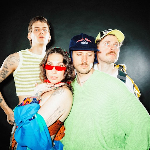 Drei Männer und eine Frau schauen in die Kamera.