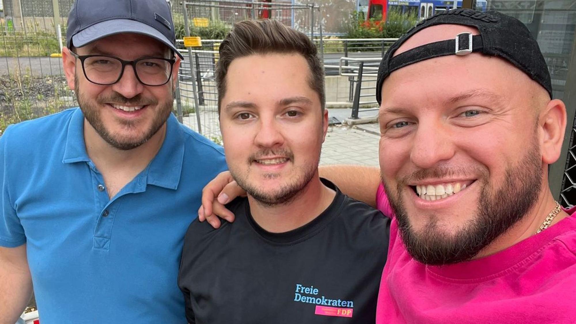 Auf dem Bild sind drei junge Männer zu sehen, die eine Müllsammelaktion gestartet haben.