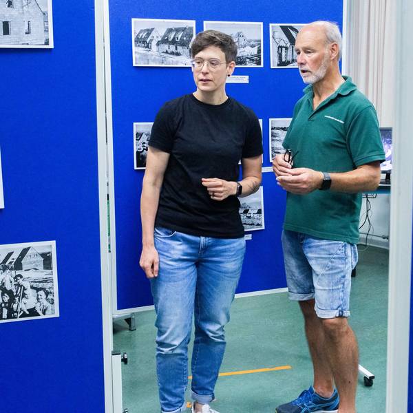 Stadtarchivarin Sarah Zeppenfeld und Wolfgang Blechmann vom Siedlerverein stehen in einer Ausstellung.