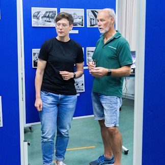 Stadtarchivarin Sarah Zeppenfeld und Wolfgang Blechmann vom Siedlerverein stehen in einer Ausstellung.