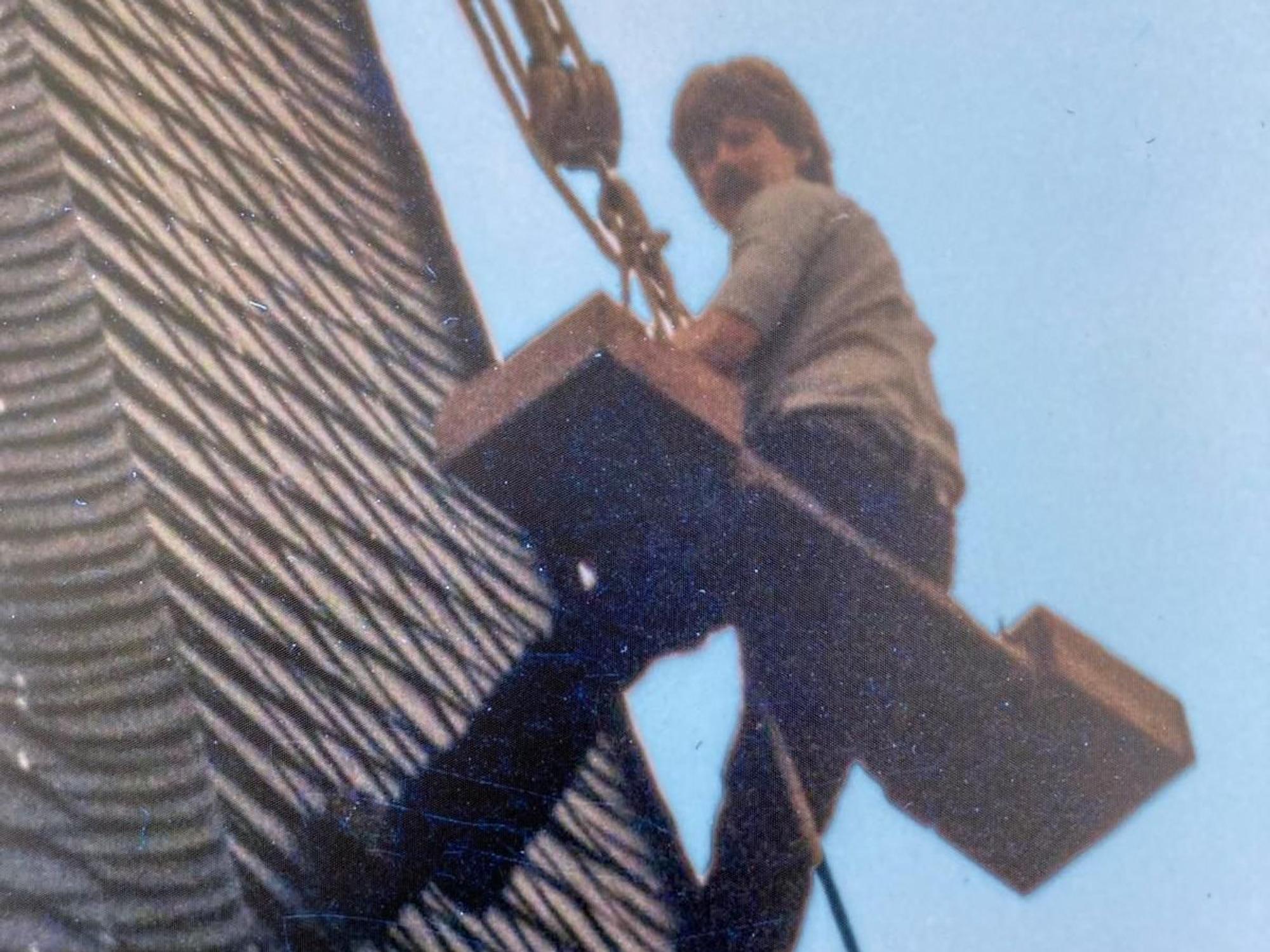 Ein Handwerker seilt sich an einem Kirchturm ab.